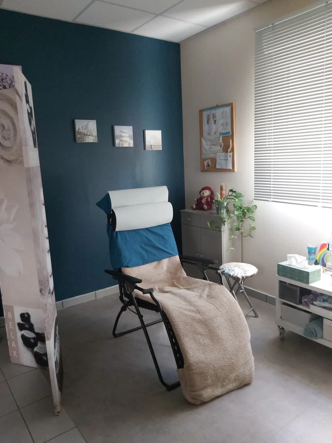 Fauteuil relax avec une couverture beige dans la salle de réflexologie.